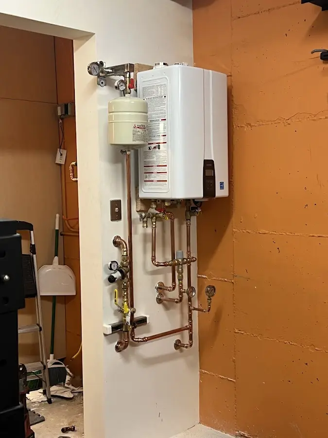 Plumbing technician inspecting water heater connections in Knightdale